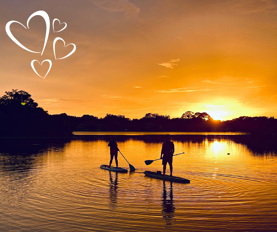 Couple on paddleboards admiring sunset